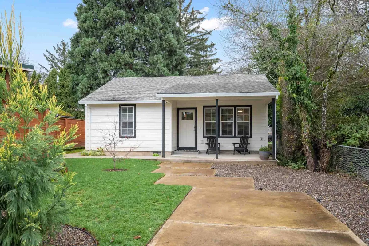 An exterior shot highlighting a charming front porch, green lawn, and welcoming pathway. The space evokes quiet mornings, friendly gatherings, and outdoor relaxation, with a clear connection between the home and its neighborhood surroundings.